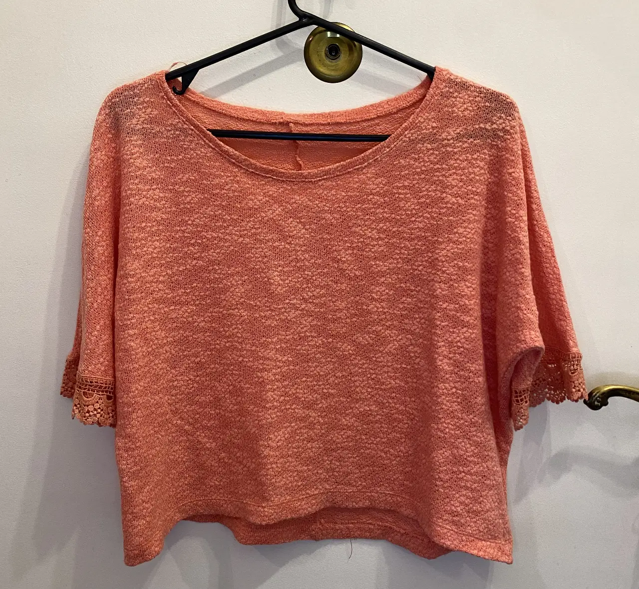 Blusa de tejido calado en color durazno, con mangas 3/4 y detalles de encaje en los puños. Marca Sol de Otoño.