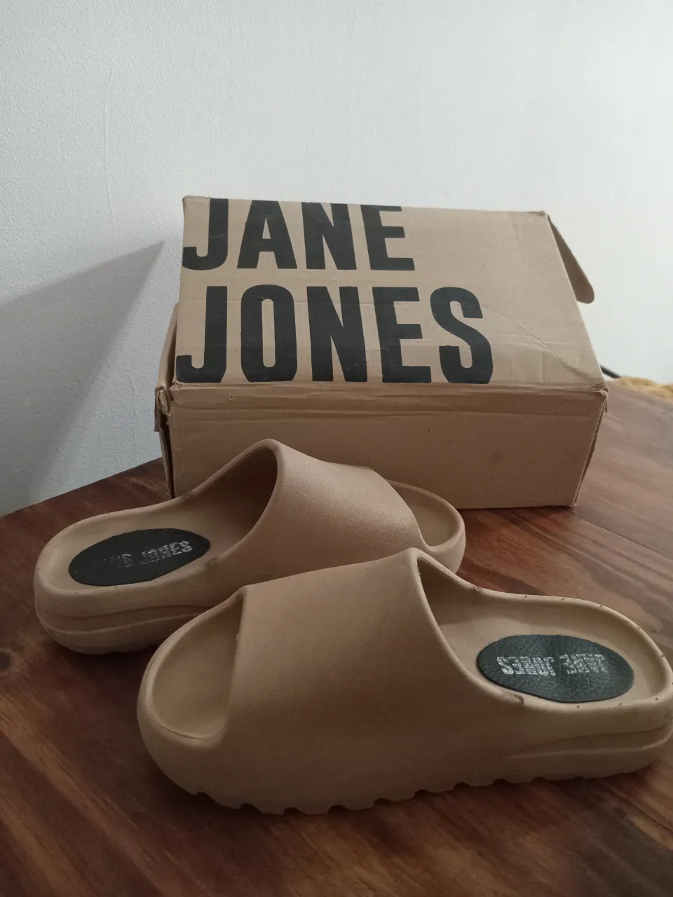 Ojotas tipo chanclas color tiza, con tira ancha y suela gruesa. "JANE JONES" .