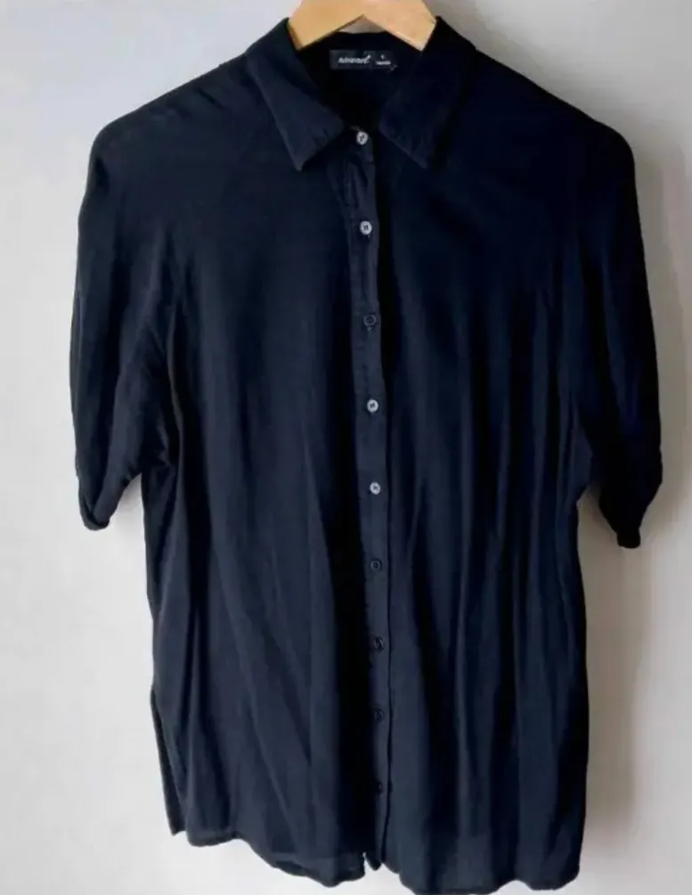 Camisa negra de manga corta, con cuello y botones. Ideal para un look casual o semi formal. Talle S.