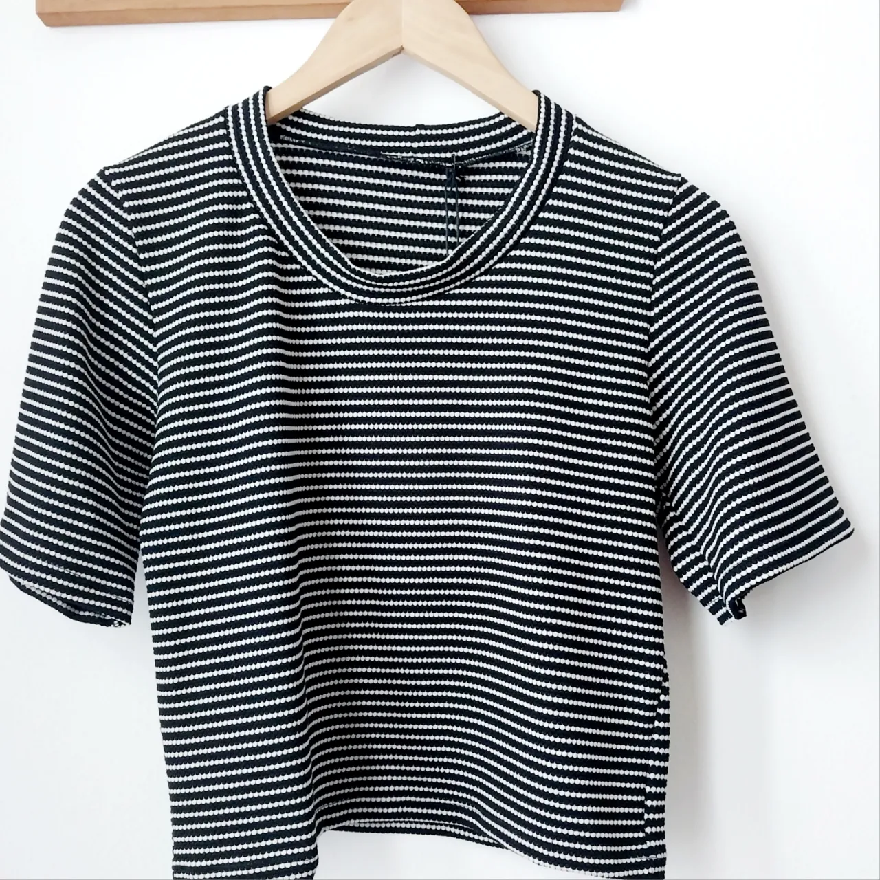 Remera a rayas blancas y negras, con mangas cortas y cuello redondo.medidas,ancho:46cmlargo:51cm.