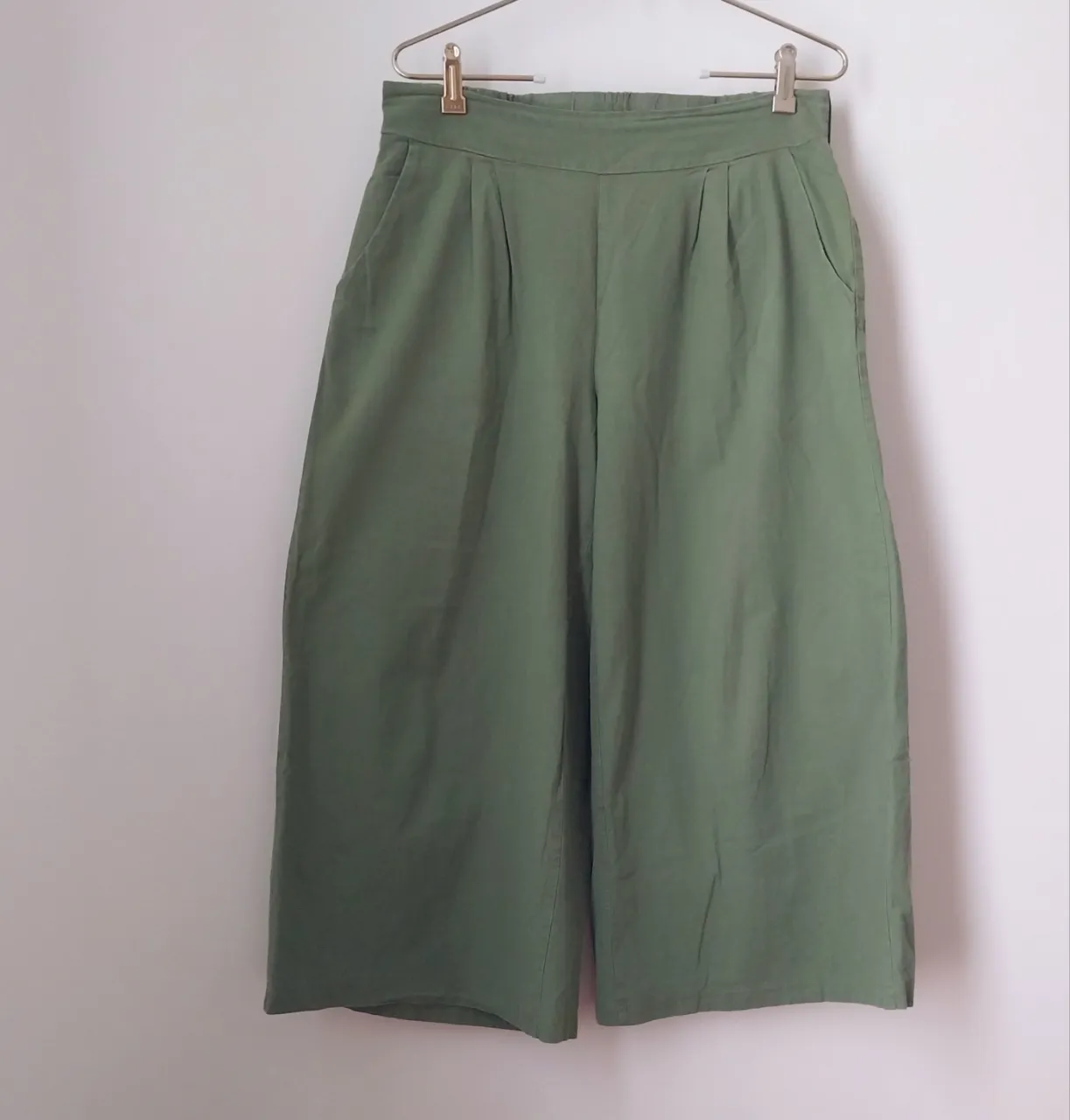 Pantalón culotte de color verde liso, con bolsillos laterales y cintura elastizada. Diseño amplio y cómodo, ideal para un look casual y fresco.medidas sin estirar:cintura:39cm.tiro:29cm.cadera:62cm.largo:88cm.