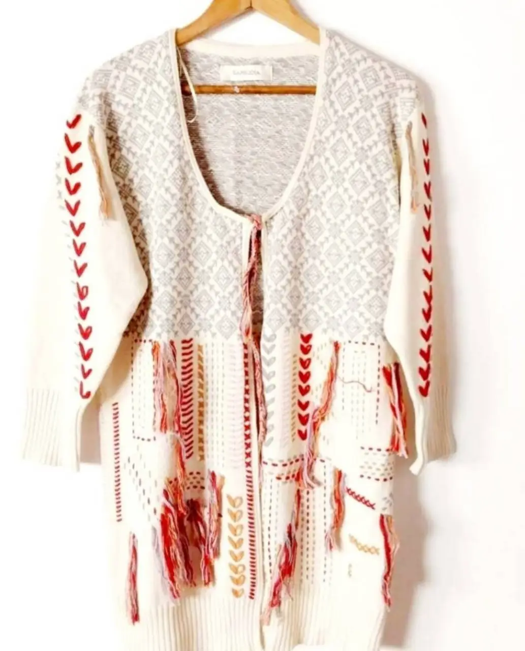Cardigan largo de tejido artesanal con detalles bordados y flecos. Ideal para un look bohemio y casual.
