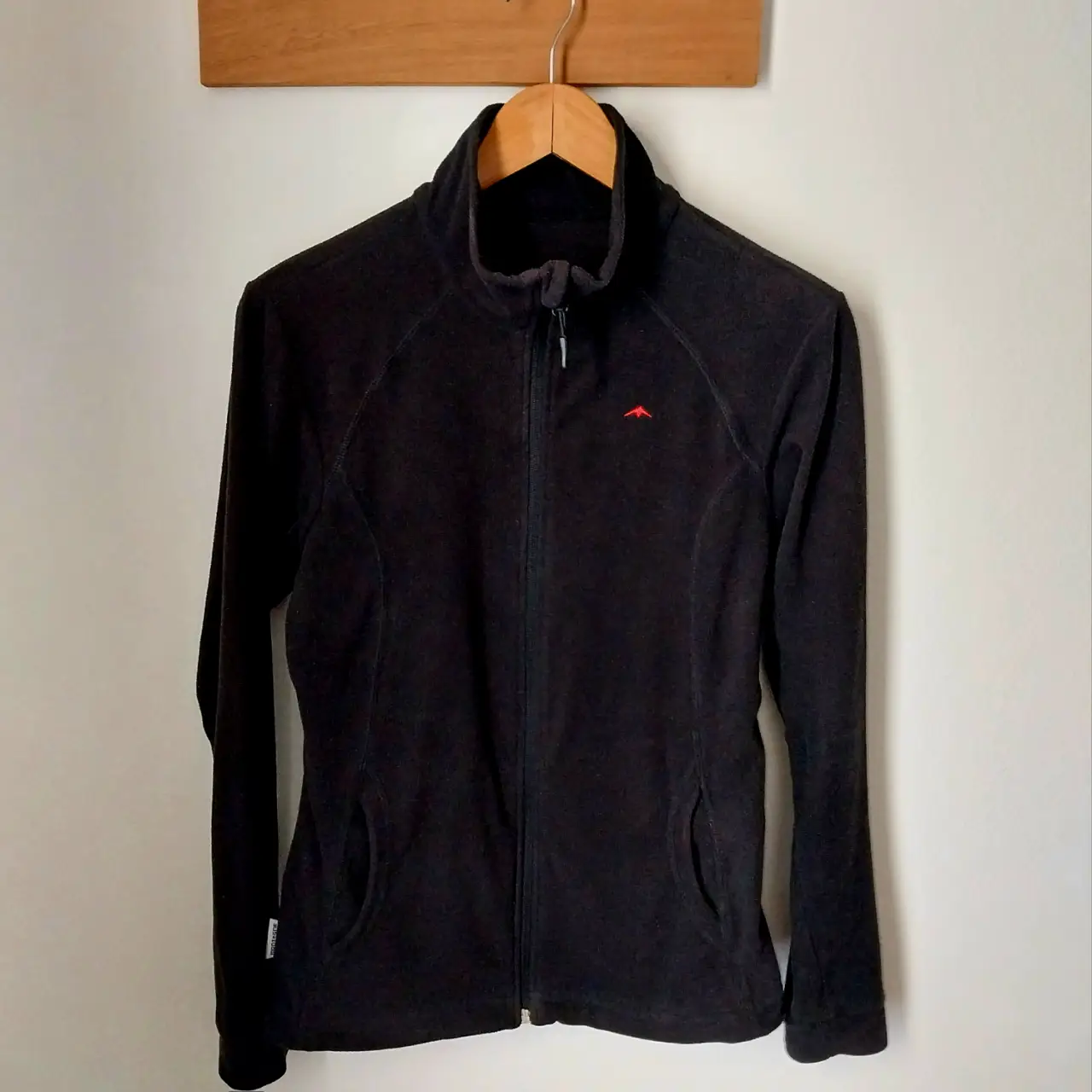 Buzo con cierre Montagne, color negro, con logo rojo. Ideal para actividades al aire libre o uso diario. Talle no especificado.