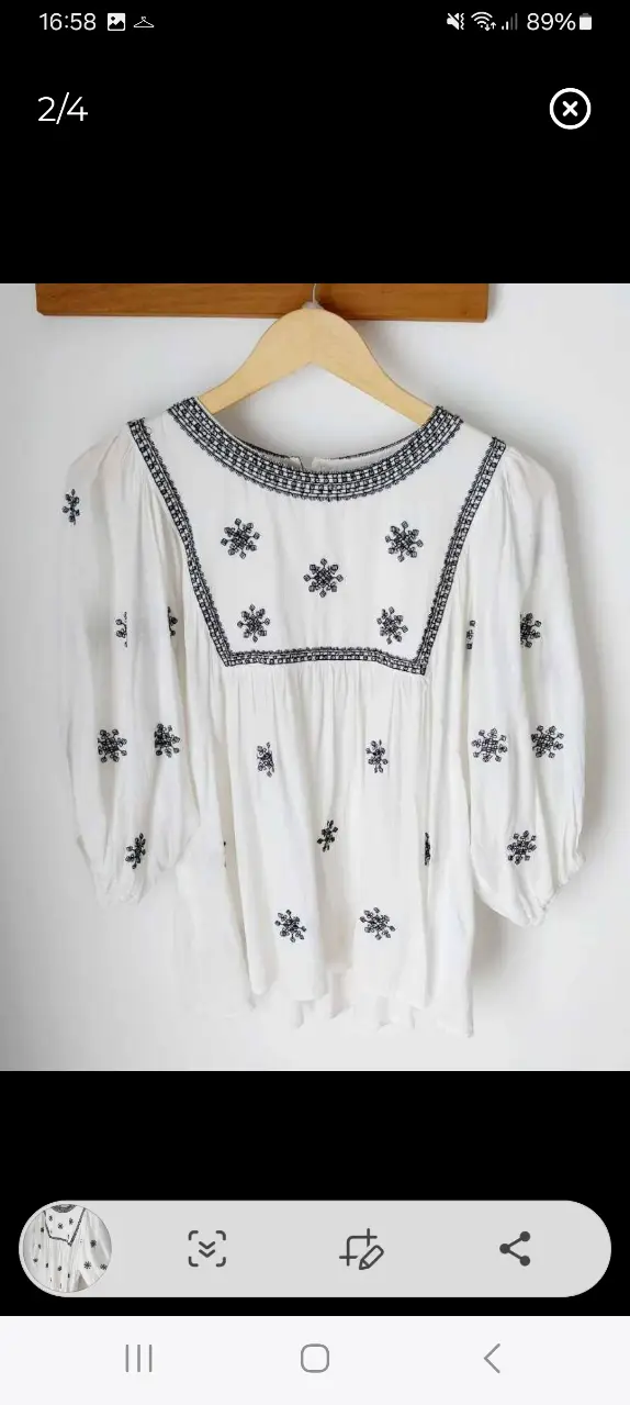 Blusa blanca con bordados en negro, estilo boho. Ideal para un look casual y fresco.