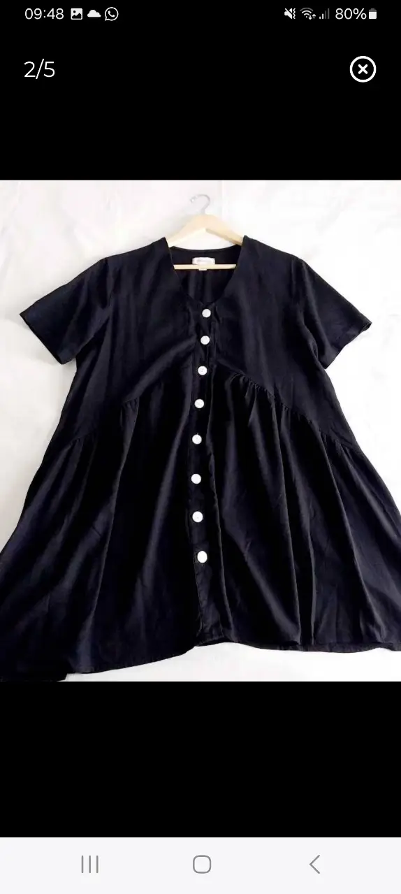 Vestido midi negro con botones blancos. Corte en A, ideal para un look casual y cómodo. Perfecto para el día a día.