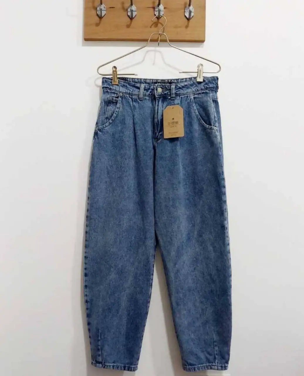 Jeans de mujer, tiro alto, estilo mom, con un lavado azul claro. Posee bolsillos delanteros y traseros. Ideal para un look casual y cómodo.