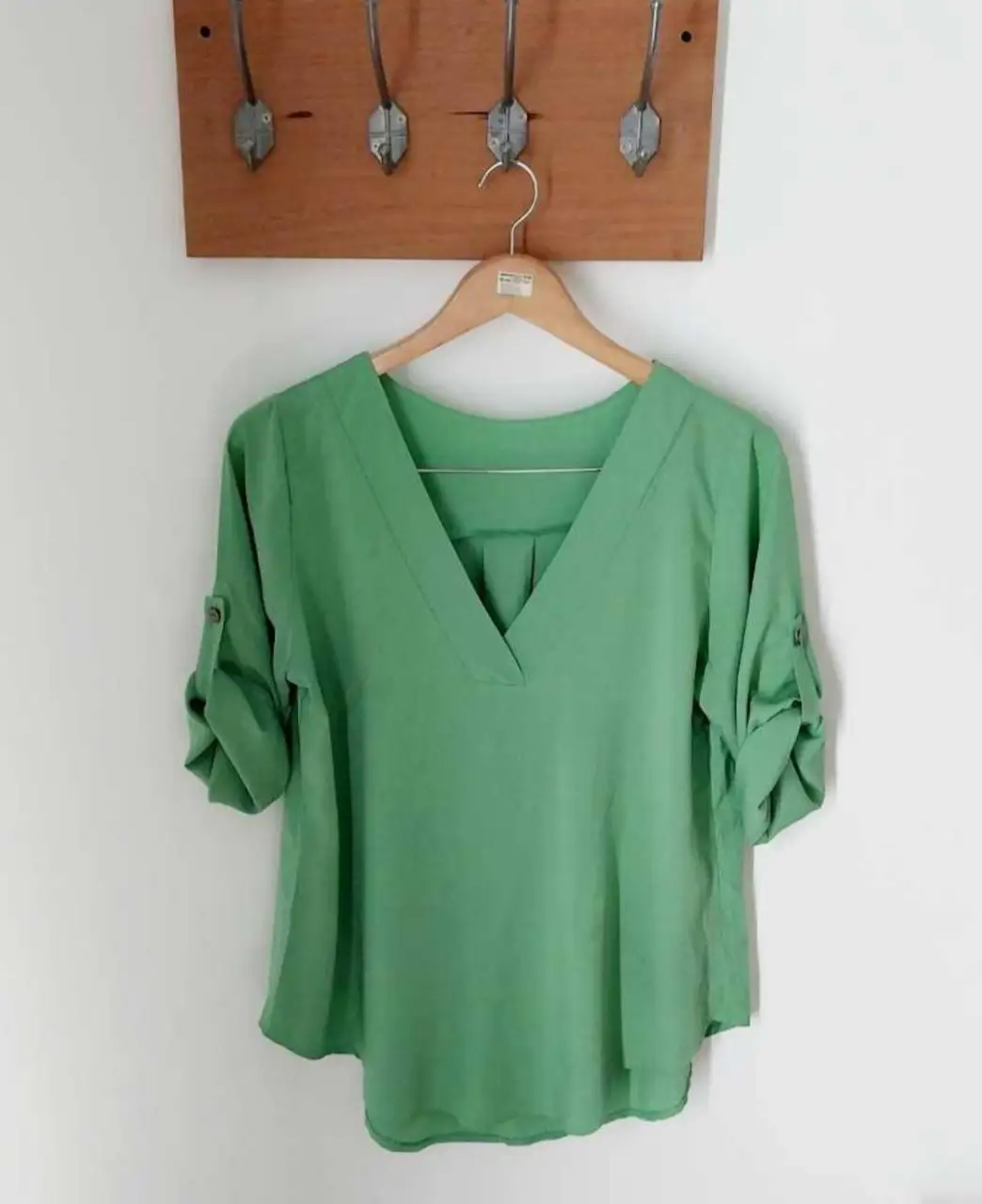 Blusa verde con cuello en V y mangas 3/4,largas y tres cuartos para sujetar. Ideal para un look casual y fresco.