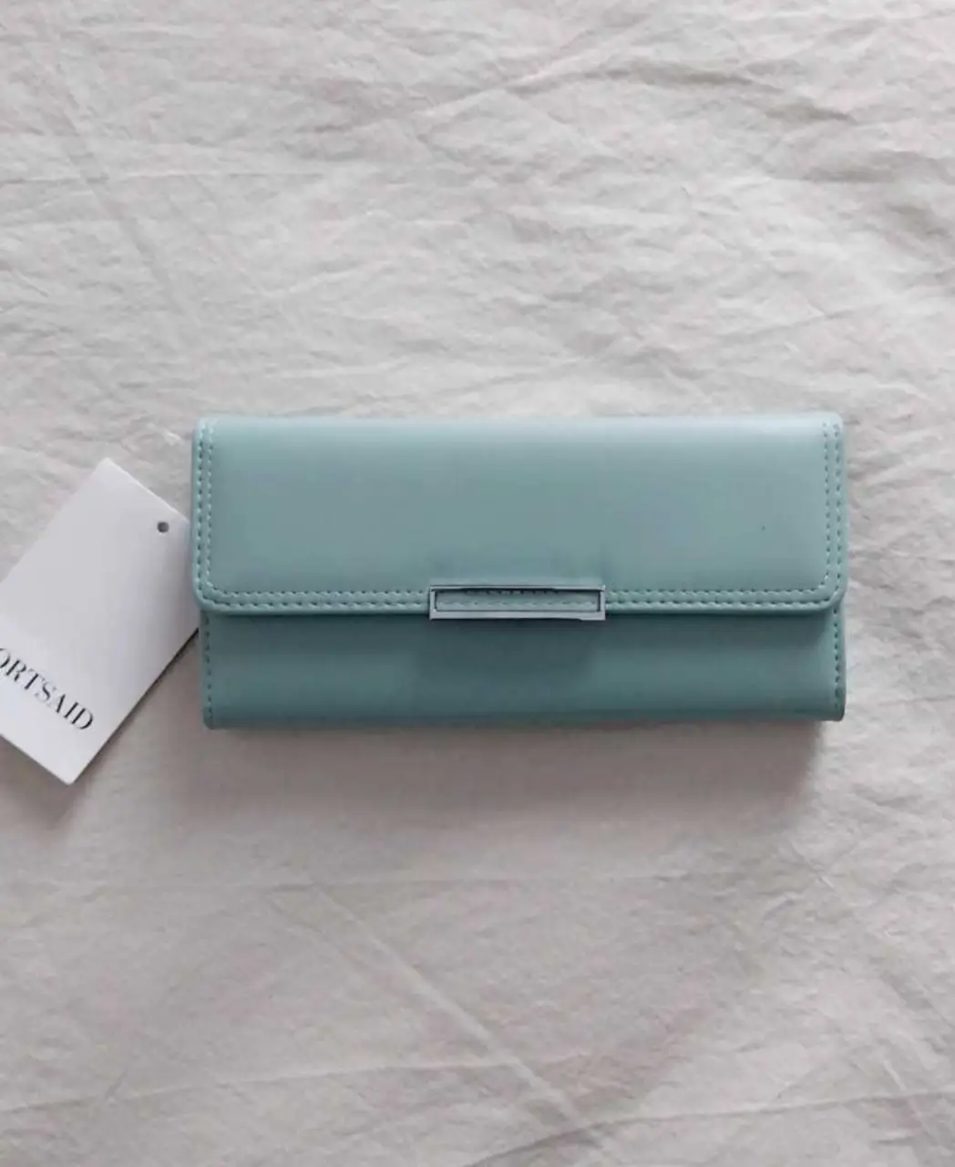 Billetera de mujer Ports Said, color celeste, con cierre y compartimentos internos. Ideal para organizar tus pertenencias con estilo.