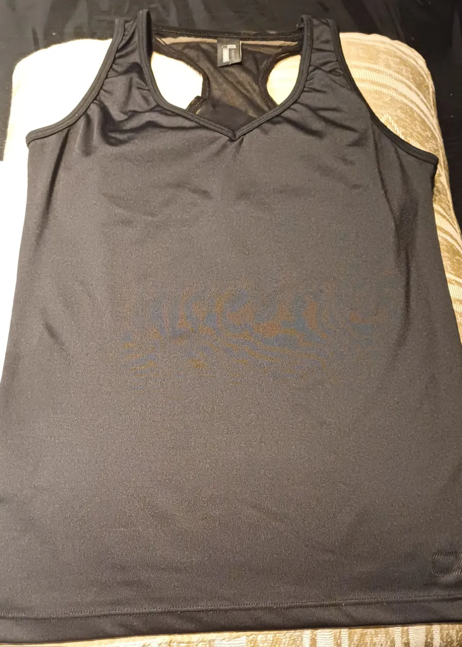 Musculosa deportiva negra con espalda estilo nadadora y detalles de malla. Ideal para entrenamientos. reforzada en la parte del busto. contorno de sisa a sisa tomada en plano 38 cede hasta 41 cm  largo total 56cm.
estado excelente. 