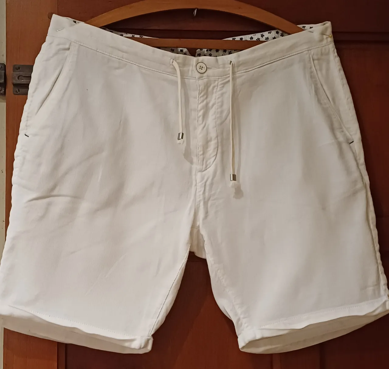 Shorts de gabardina blancos, tiro medio, con cordón ajustable en la cintura y bolsillos funcionales. Perfectos para un look casual y cómodo en días de calor.