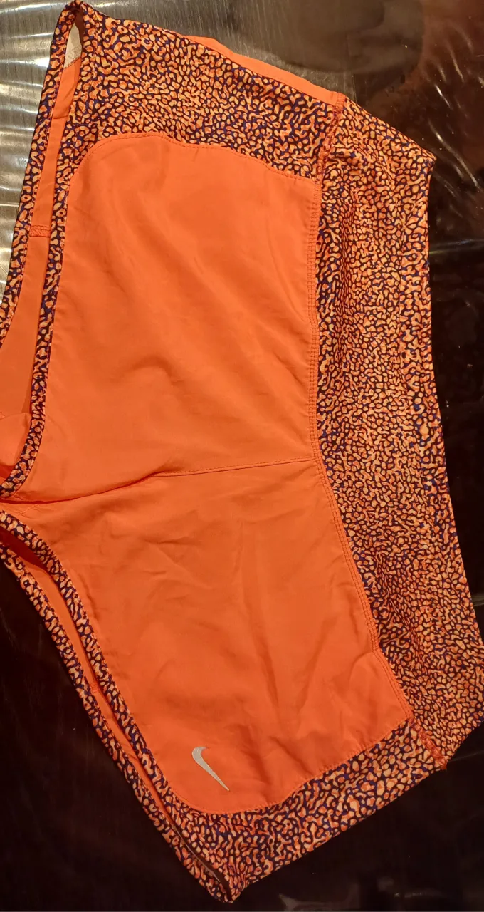 Short deportivo Nike naranja con estampado. Ideal para running y entrenamientos. cintura ajustable von cordon. bombacha e lygra interior.  cintura tomada en plano 39cm. cadera medida en plano  52cm.  tiro delantero 23cm tiro trasero 36cm. estado excelente 