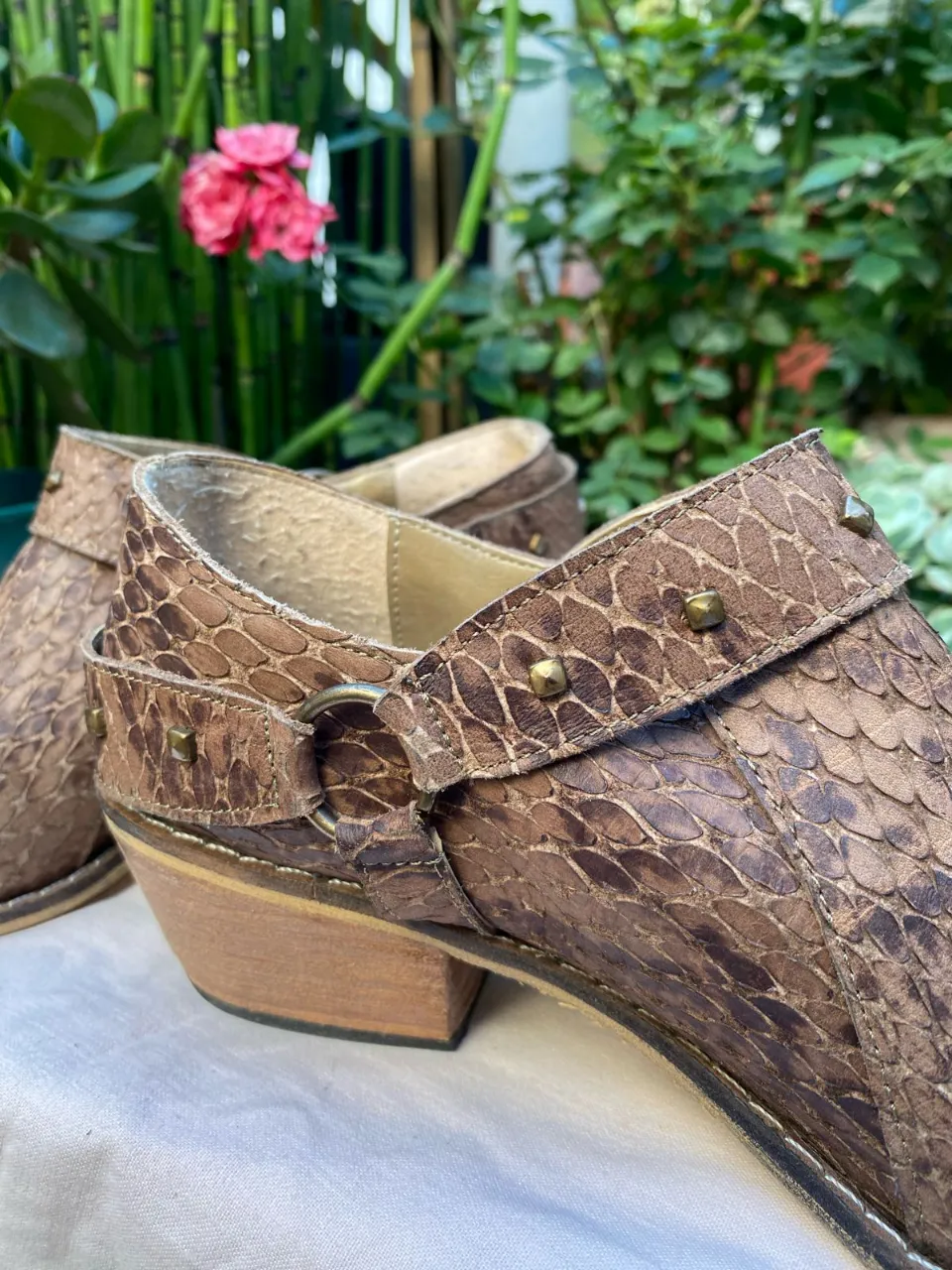 Botines de cuero con diseño de reptil, detalles de tachas doradas y hebilla. Ideales para un look boho o casual con un toque de estilo.