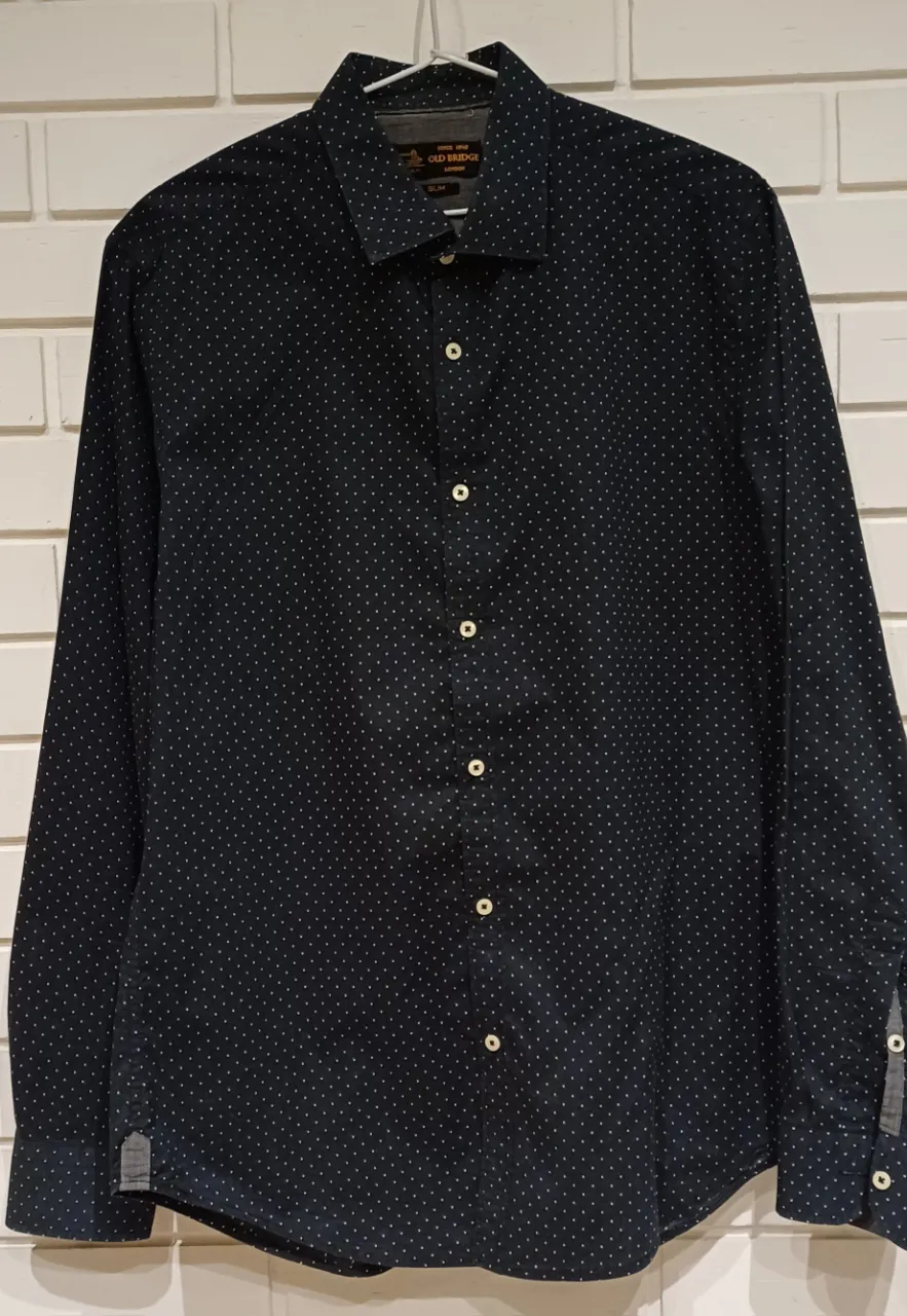 Camisa de vestir manga larga con estampa de puntos blancos sobre fondo azul oscuro. Corte slim fit, ideal para un look elegante y moderno. ancho de hombros 42cm  ancho de sisa a sisa 54cm largo mangas 64cm  largo total. 71cm. 