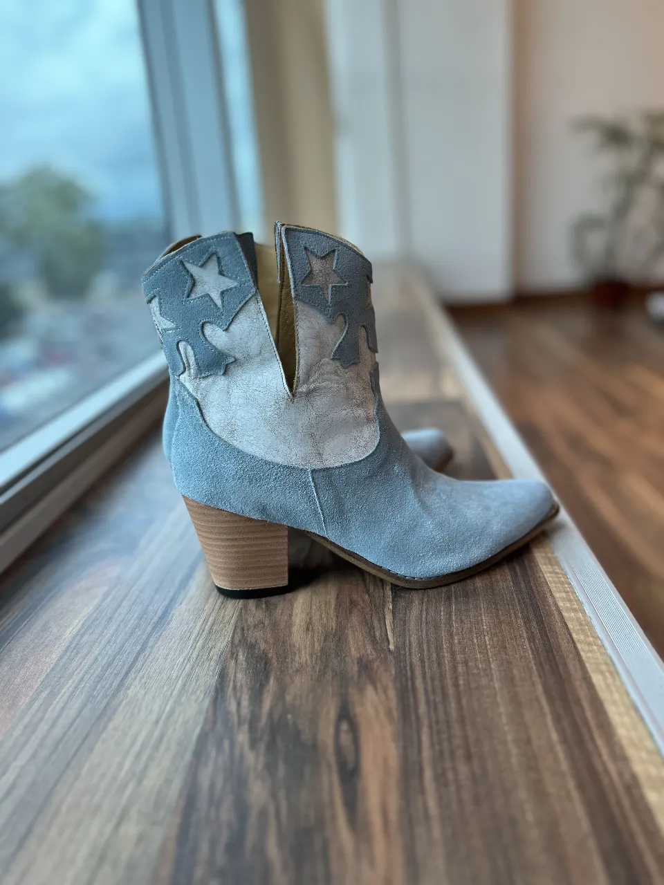 Botas de gamuza celeste con detalles de estrellas en blanco. Estilo cowboy, ideales para un look casual y canchero.