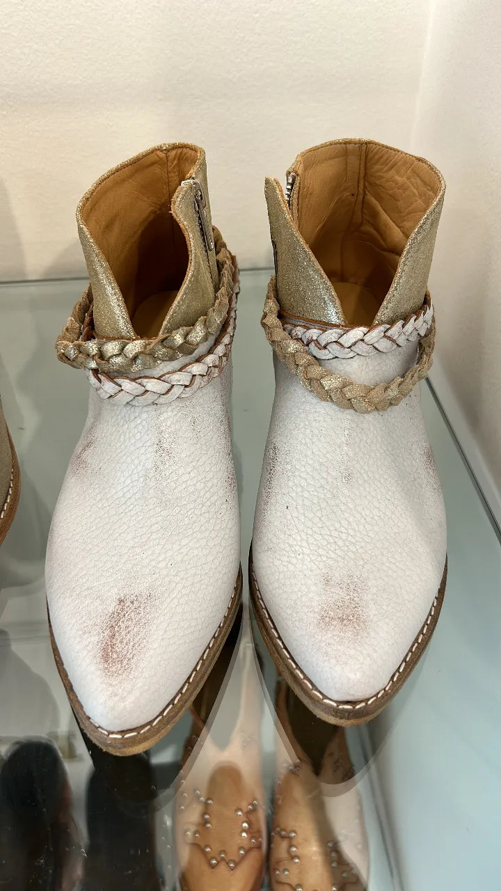 Botines blancos con detalles dorados y trenzados. Ideales para un look casual y moderno.