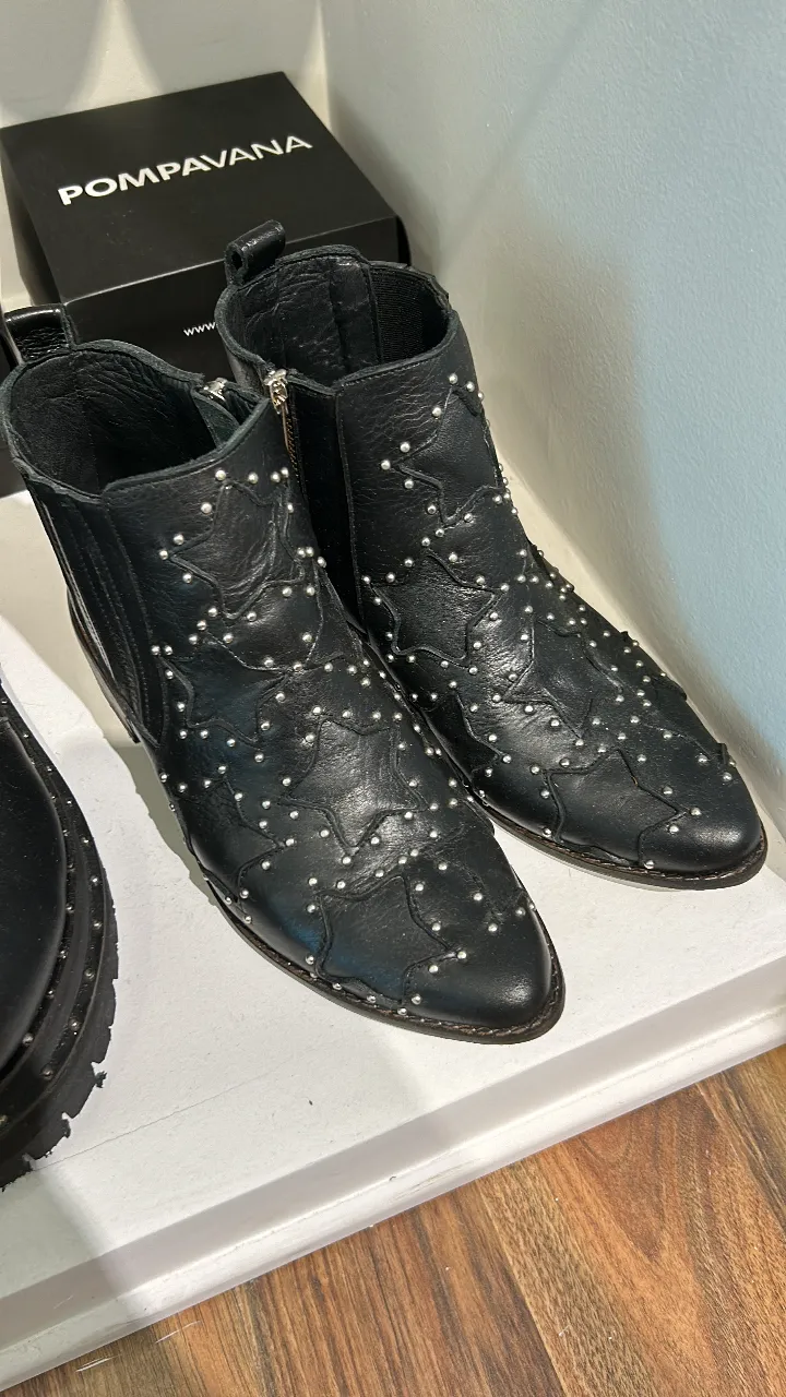 Botines de cuero negro con tachas plateadas en forma de estrella. Diseño moderno y audaz, ideales para un look rocker o casual.