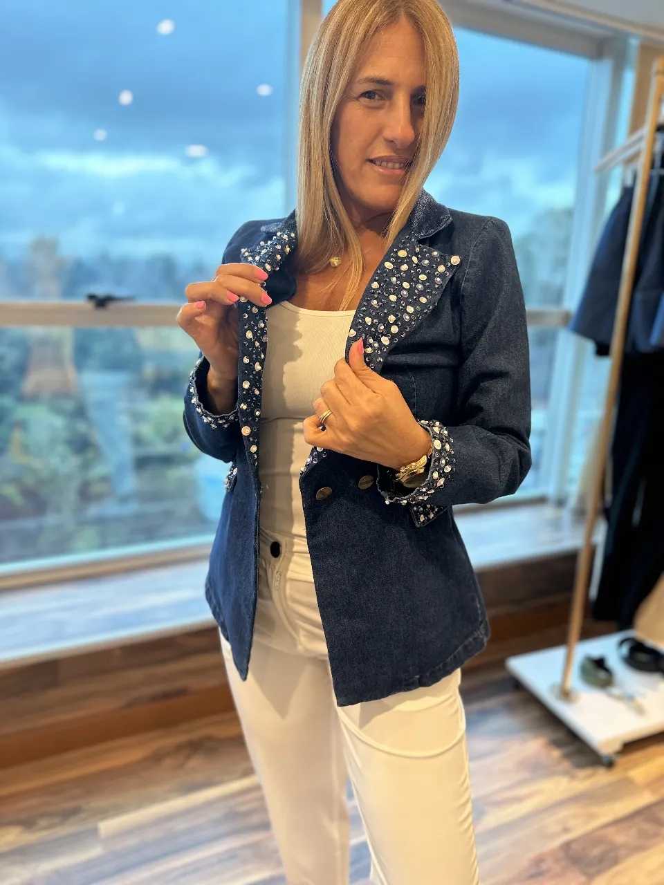 Blazer de jean azul oscuro con detalles de perlas blancas en solapas y puños. Ideal para un look elegante y moderno.
