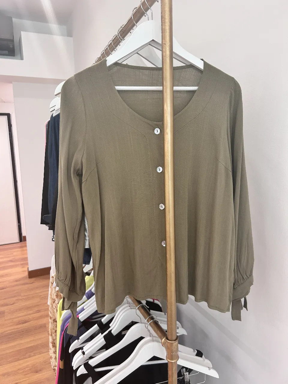Blusa de manga larga en color verde oscuro, con botones y cuello redondo. Ideal para un look casual y elegante.