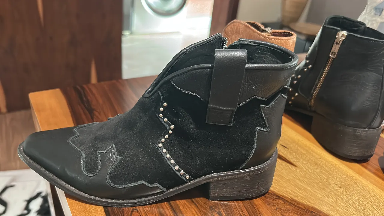 Botines negros de cuero con detalles de tachas y diseño de estilo cowboy. Ideales para un look rockero y canchero.