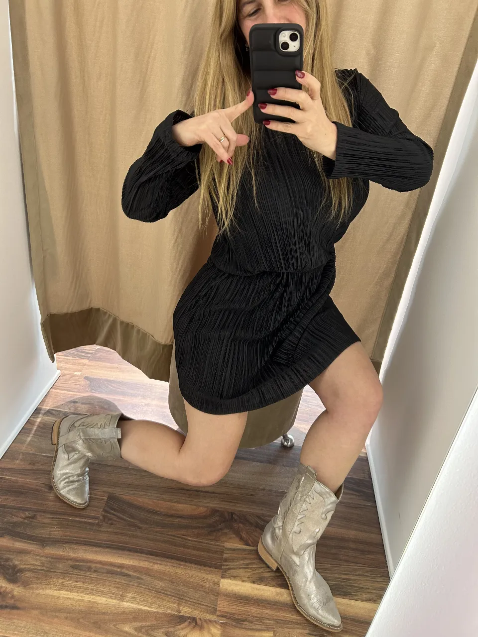 Vestido mini negro plisado, con mangas largas y botas plateadas. Ideal para una salida.