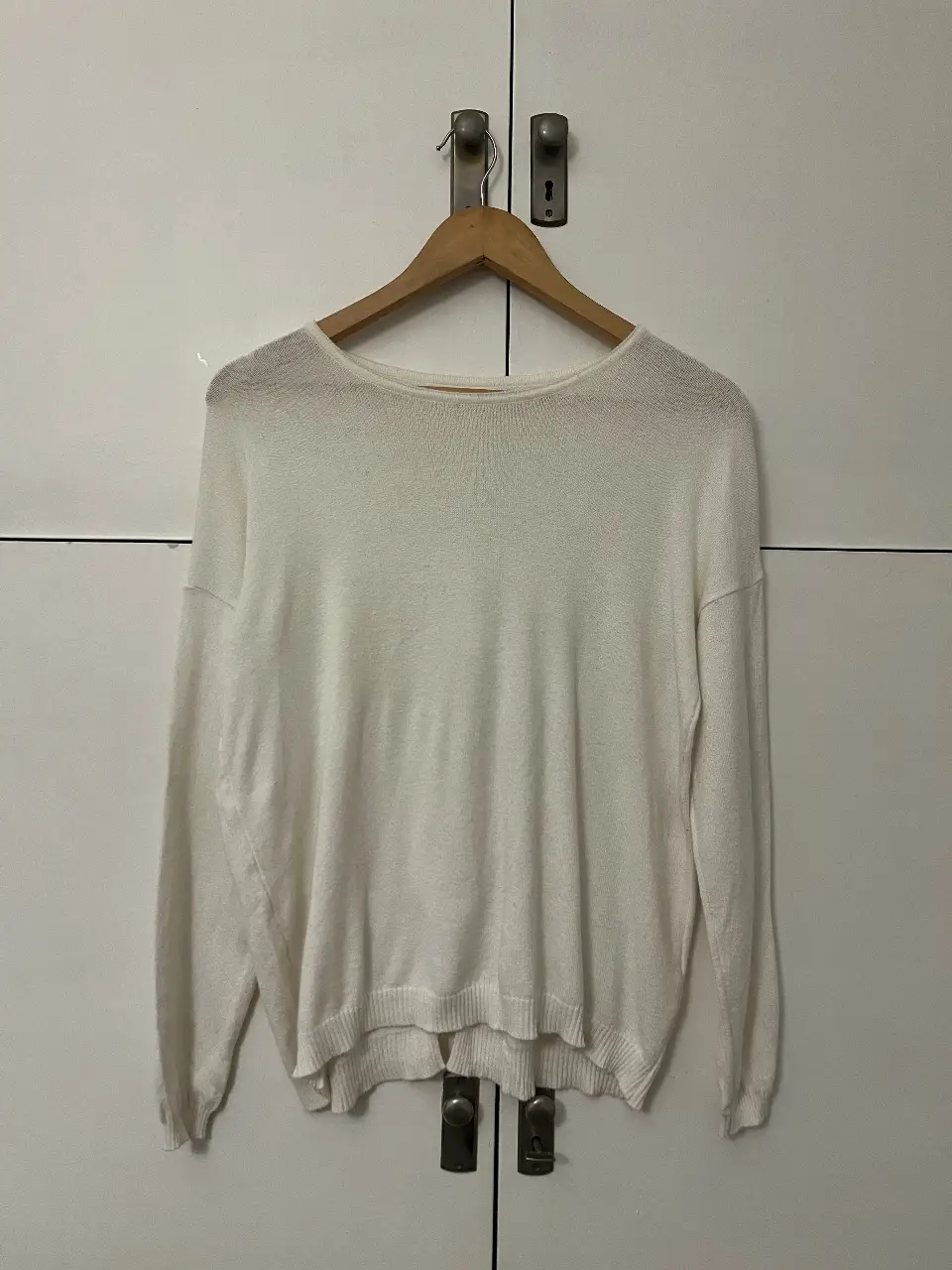 Sweater blanco de tejido ligero con detalle de moños en la espalda. Ideal para un look casual y femenino.