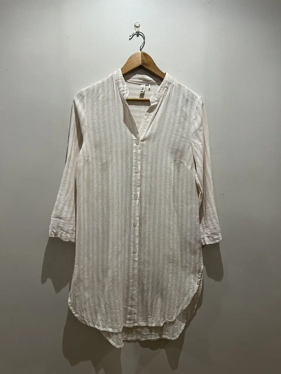 Camisa a rayas verticales en tonos crudos y blancos, con cuello mao y mangas 3/4. Ideal para un look casual y fresco.