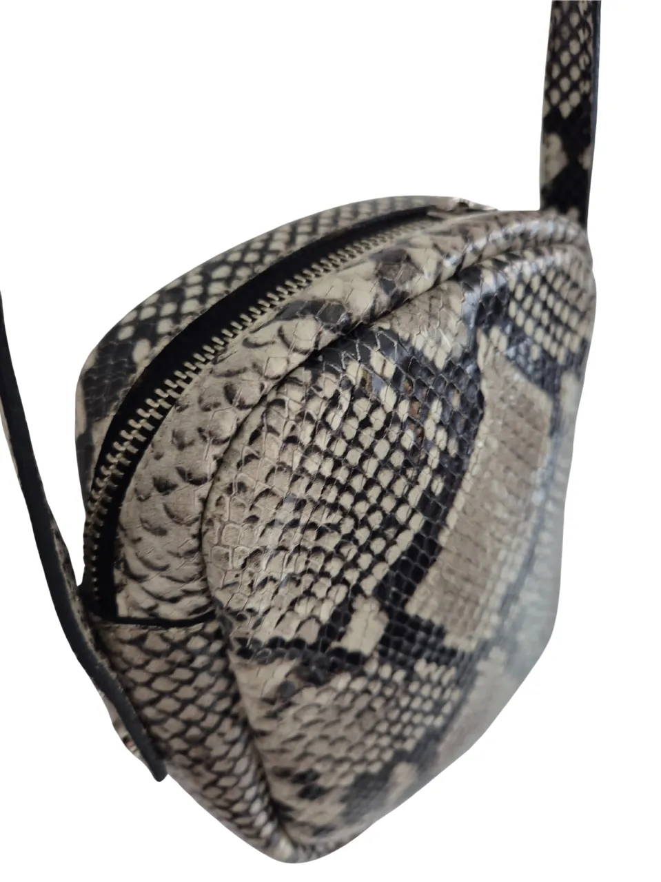 Bandolera con estampado de serpiente en tonos grises y negros. Diseño compacto y elegante, ideal para llevar lo esencial. Cierre y correa ajustables.