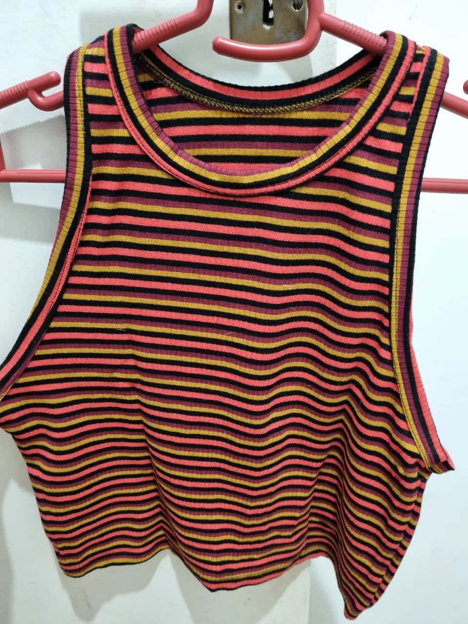 Musculosa de mujer a rayas horizontales en tonos naranja, negro y amarillo. Ideal para un look casual y moderno.