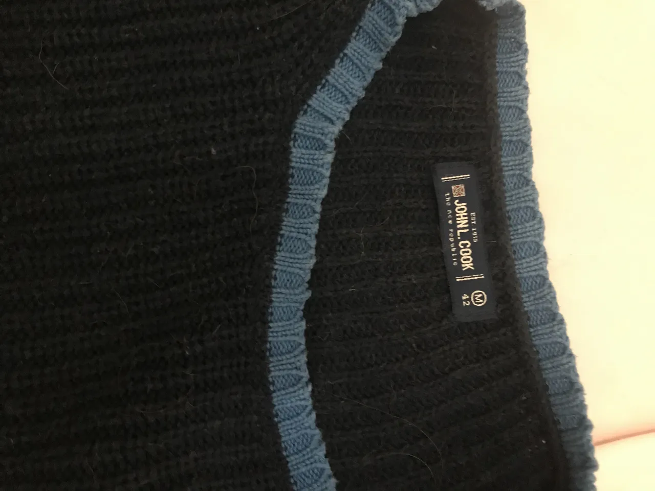 Sweater de mujer de lana color negro con detalles en azul en el cuello. Talle M. John l cook .