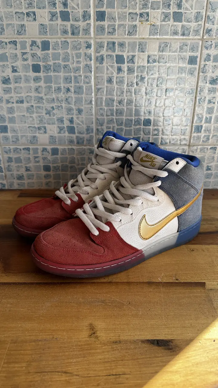 Zapatillas Nike SB Dunk High, con detalles en rojo, blanco, azul y dorado. Talle 10.5 US. Ideales para un look skater o casual.