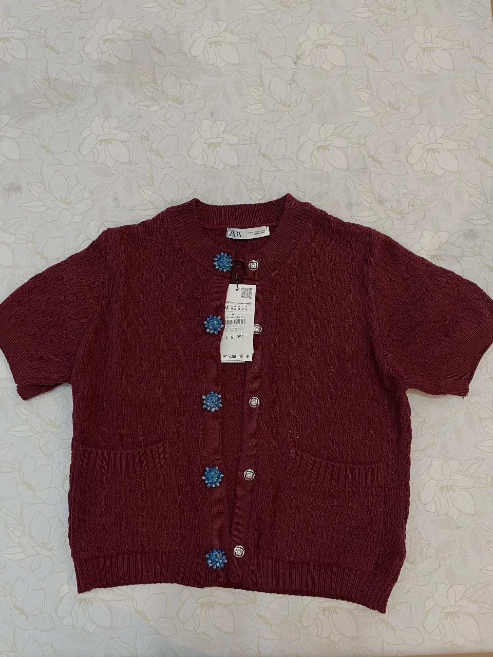 Cardigan de punto color borgoña con botones joya. Ideal para un look elegante y sofisticado.