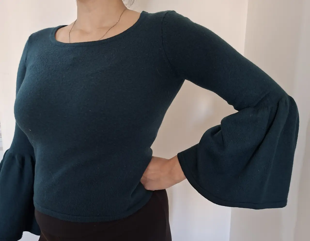 Sweater de mujer de color verde oscuro con mangas acampanadas. Ideal para un look elegante y moderno.