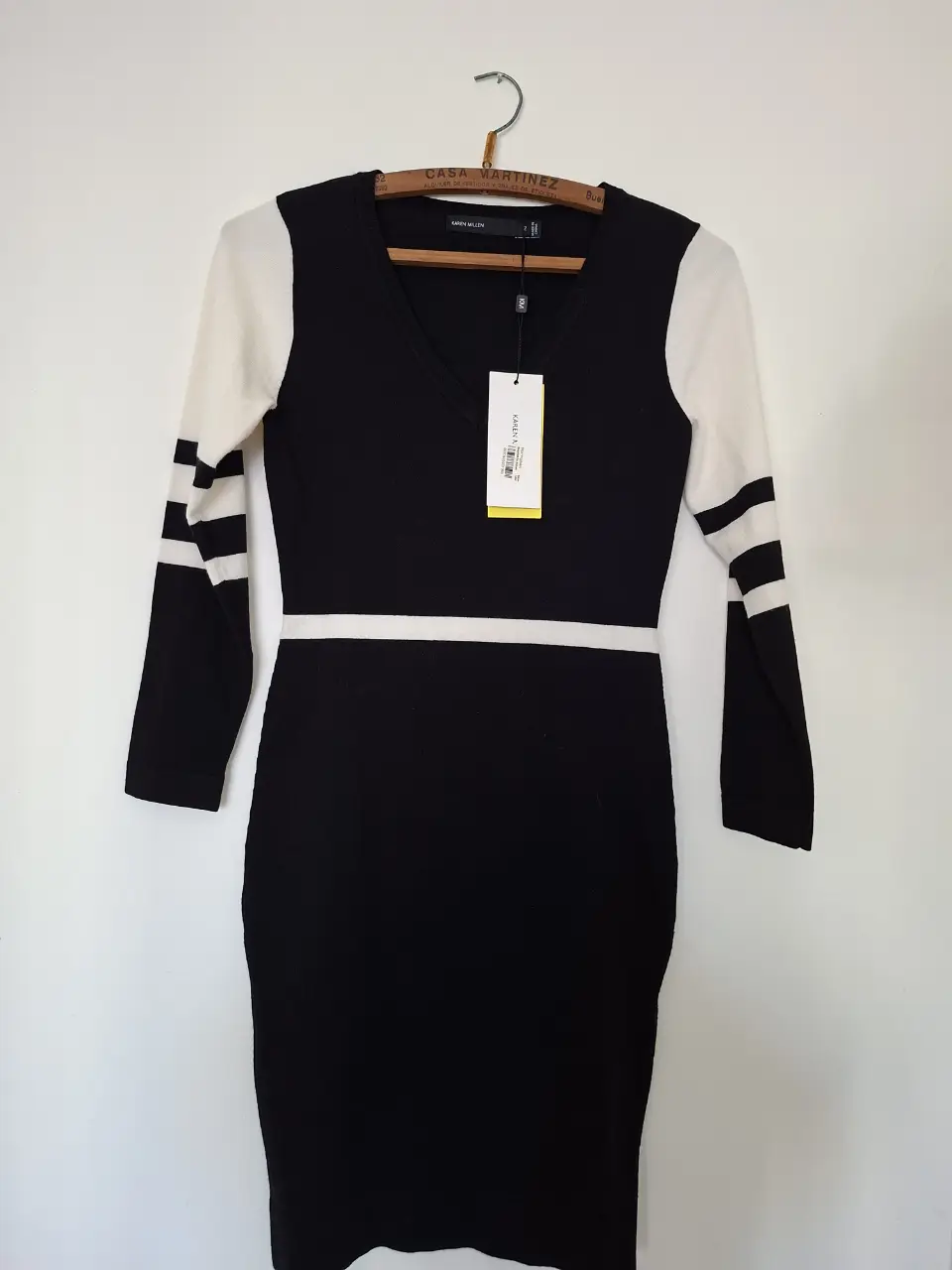 Vestido midi de punto, con mangas largas y detalles a rayas en blanco. Ideal para un look elegante y moderno.