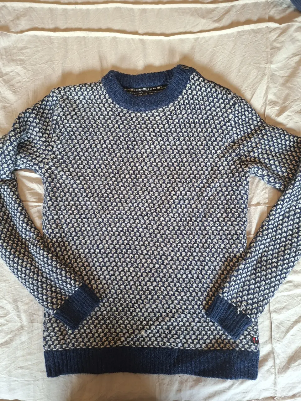 Sweater de hombre de lana, con diseño de rombos en azul y blanco. Cuello redondo y puños en azul marino. Ideal para el invierno.