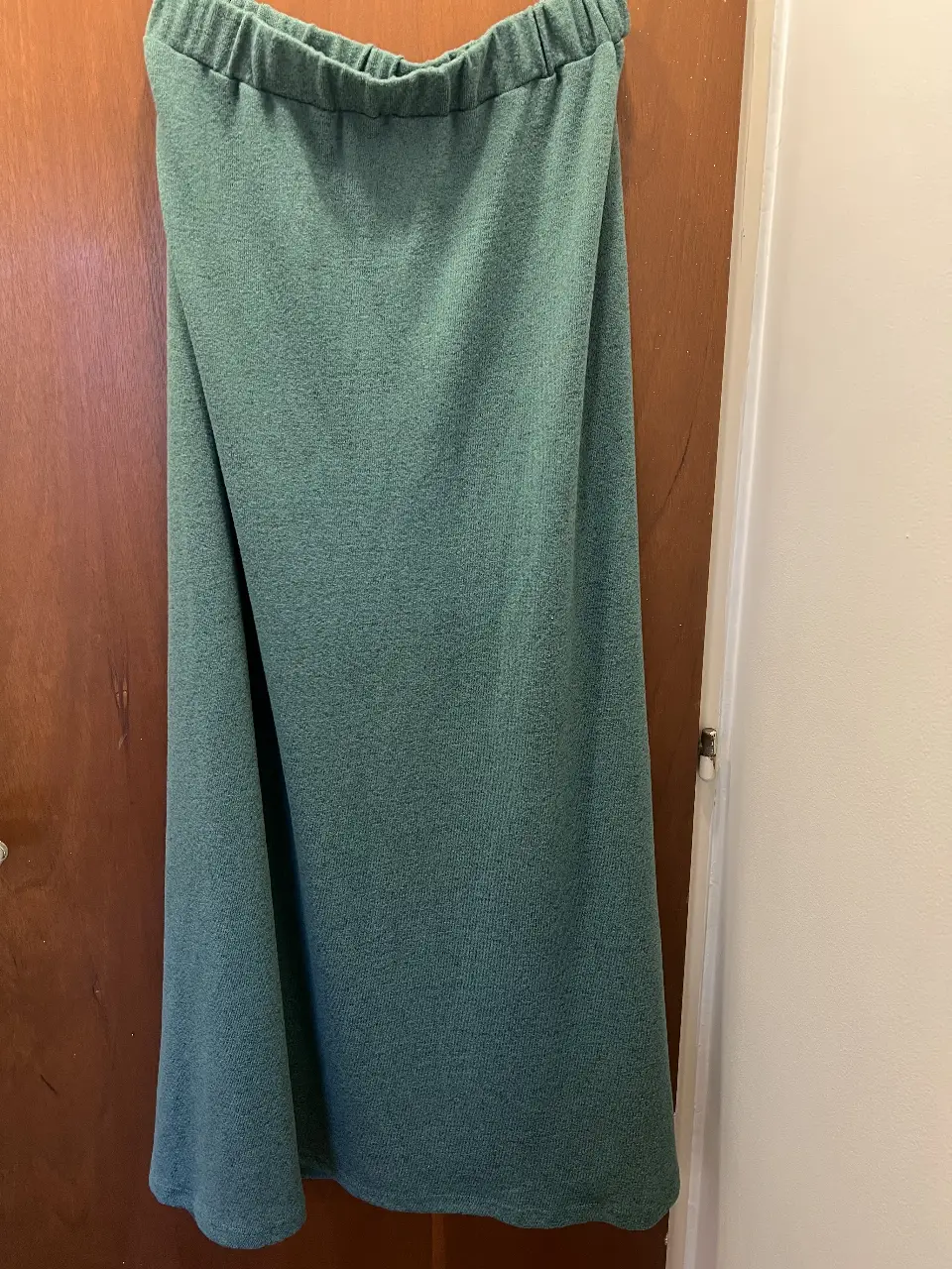 Pollera midi de tejido suave y caída fluida, ideal para un look casual y cómodo. Su color verde le da un toque fresco y versátil para combinar con diferentes estilos.