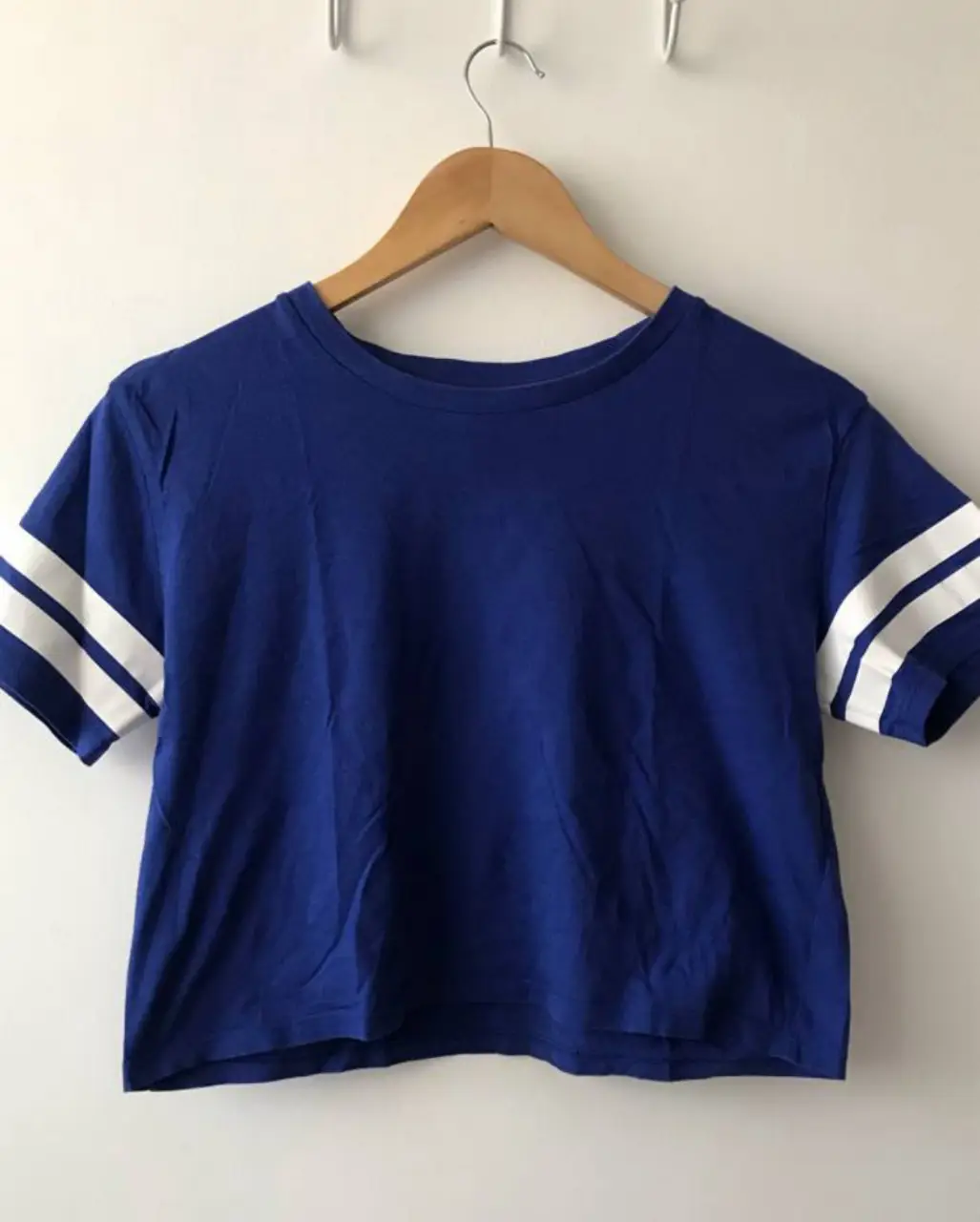 Remera crop azul con mangas cortas y detalles blancos. Ideal para un look casual y moderno.