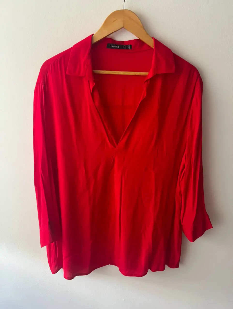 Blusa roja de Bershka, con cuello en V y mangas 3/4. Ideal para un look elegante y moderno.