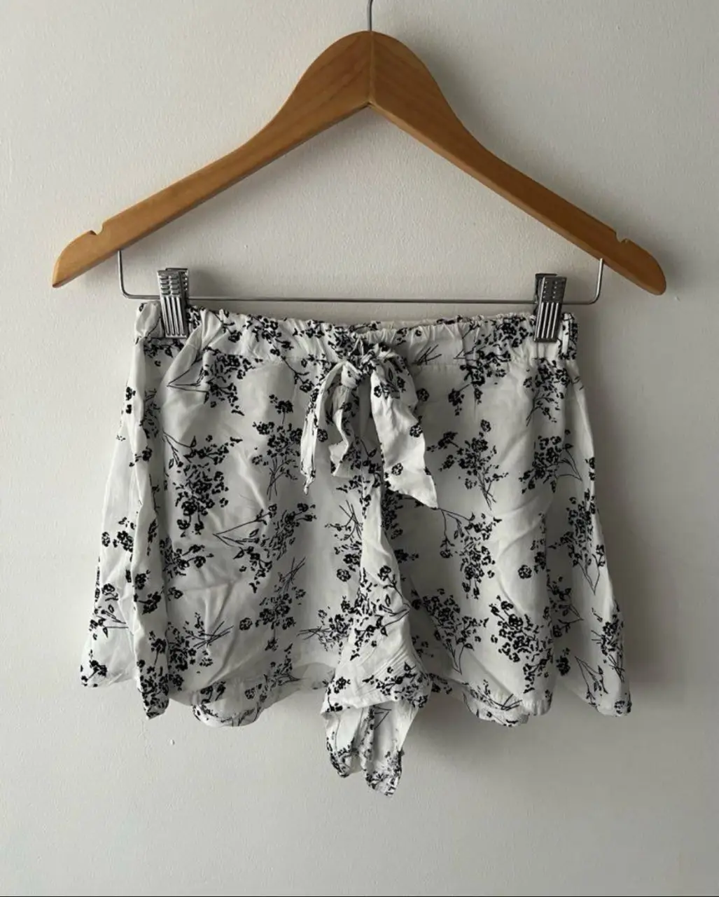 Shorts de tela liviana con estampado floral en blanco y negro. Tiene cintura elastizada con lazo para ajustar. Ideal para un look fresco y cómodo.