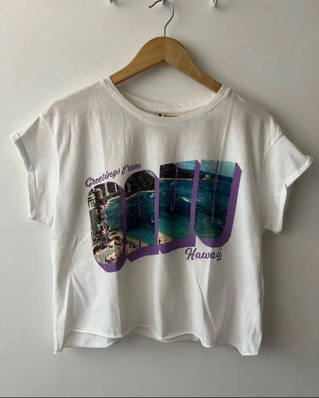 Remera crop de algodón blanca con estampado "Greetings from Oahu Hawaii". Ideal para un look casual y playero.