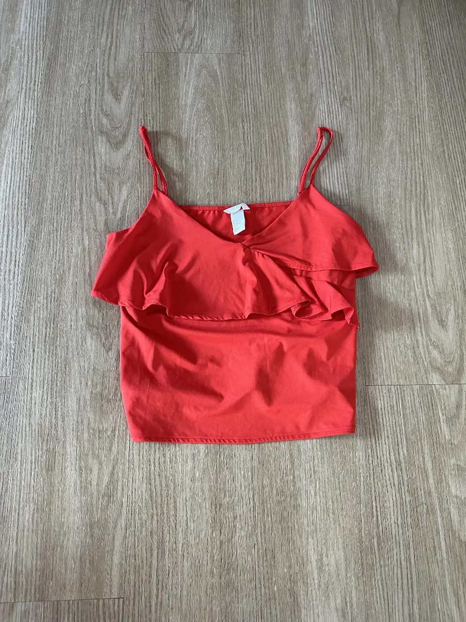 Top rojo con volados, ideal para un look fresco y femenino. Perfecto para combinar con jeans o faldas.