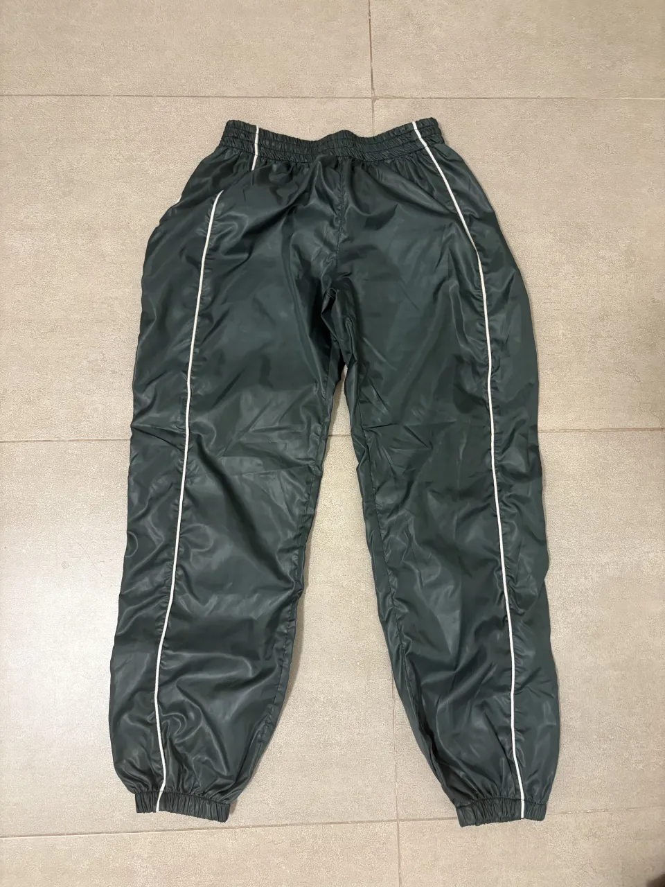 Jogging suelto verde con líneas blancas en los laterales. Cintura elastizada.