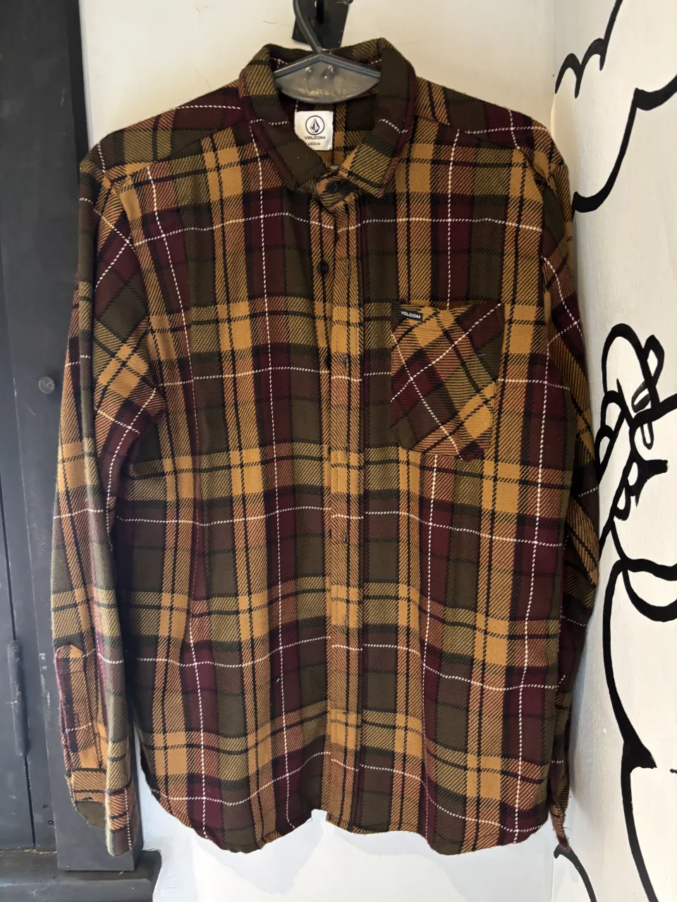 Camisa de leñador a cuadros en tonos verdes, marrones y bordó. Ideal para un look casual y cómodo.