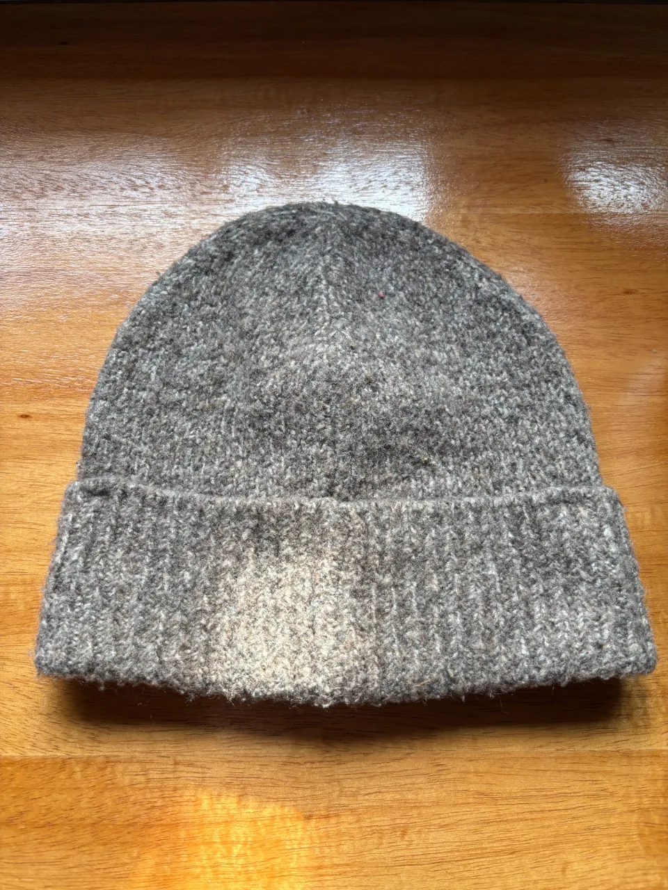 Gorro de lana tejido, ideal para mantenerte abrigado en los días fríos. Su diseño clásico y color neutro lo hacen perfecto para combinar con cualquier outfit.