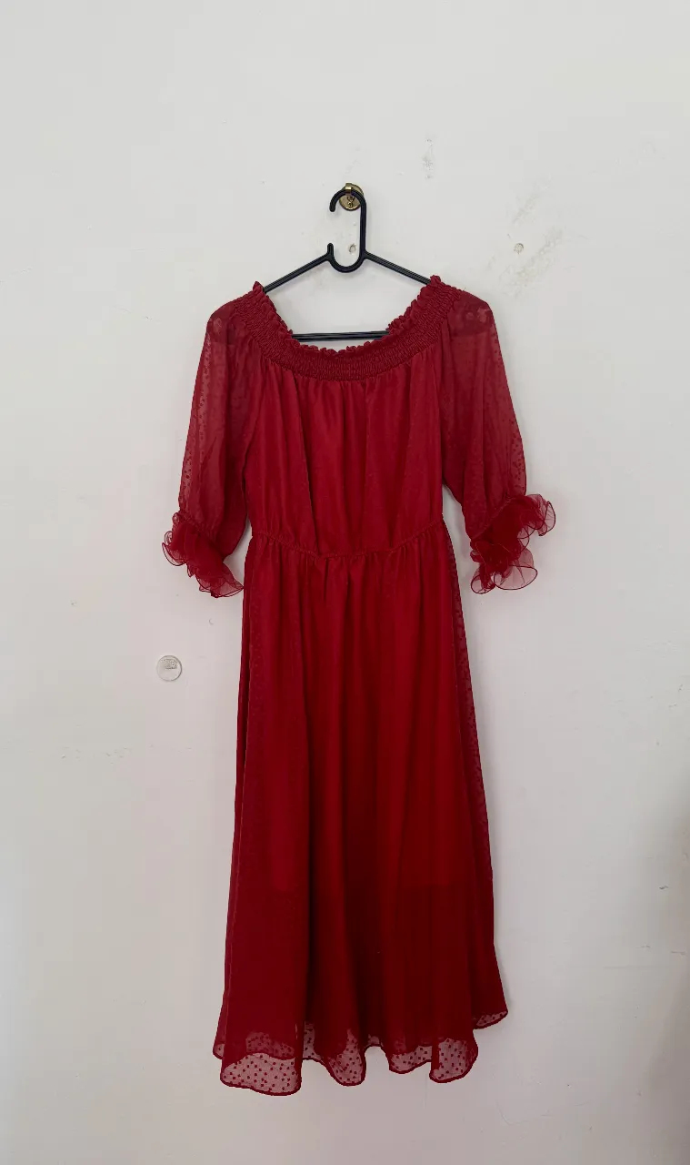 Vestido midi rojo con mangas 3/4 y detalle de volados en los puños. Escote barco con fruncido. Ideal para eventos especiales.
