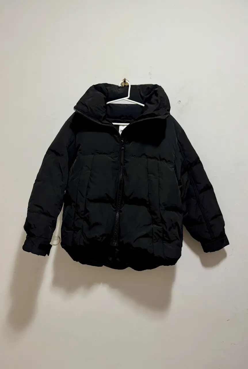 Campera de pluma negra, ideal para el invierno. Con cuello alto y cierre. Perfecta para mantenerte abrigado con estilo.