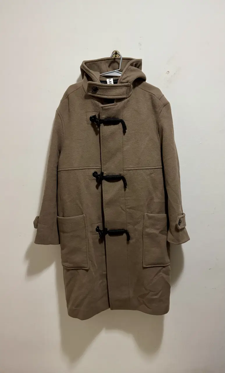 Sobretodo tipo duffle coat de color marrón. Posee capucha, botones, y bolsillos delanteros. Ideal para el invierno.