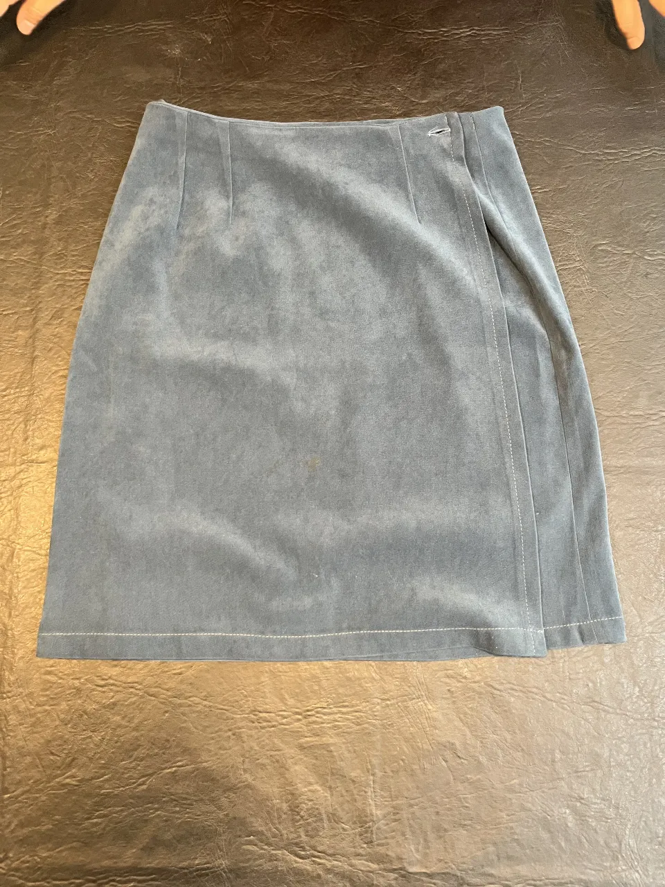 Pollera sastrera de terciopelo gris, con detalle de solapa y botón. Ideal para un look elegante y sofisticado.