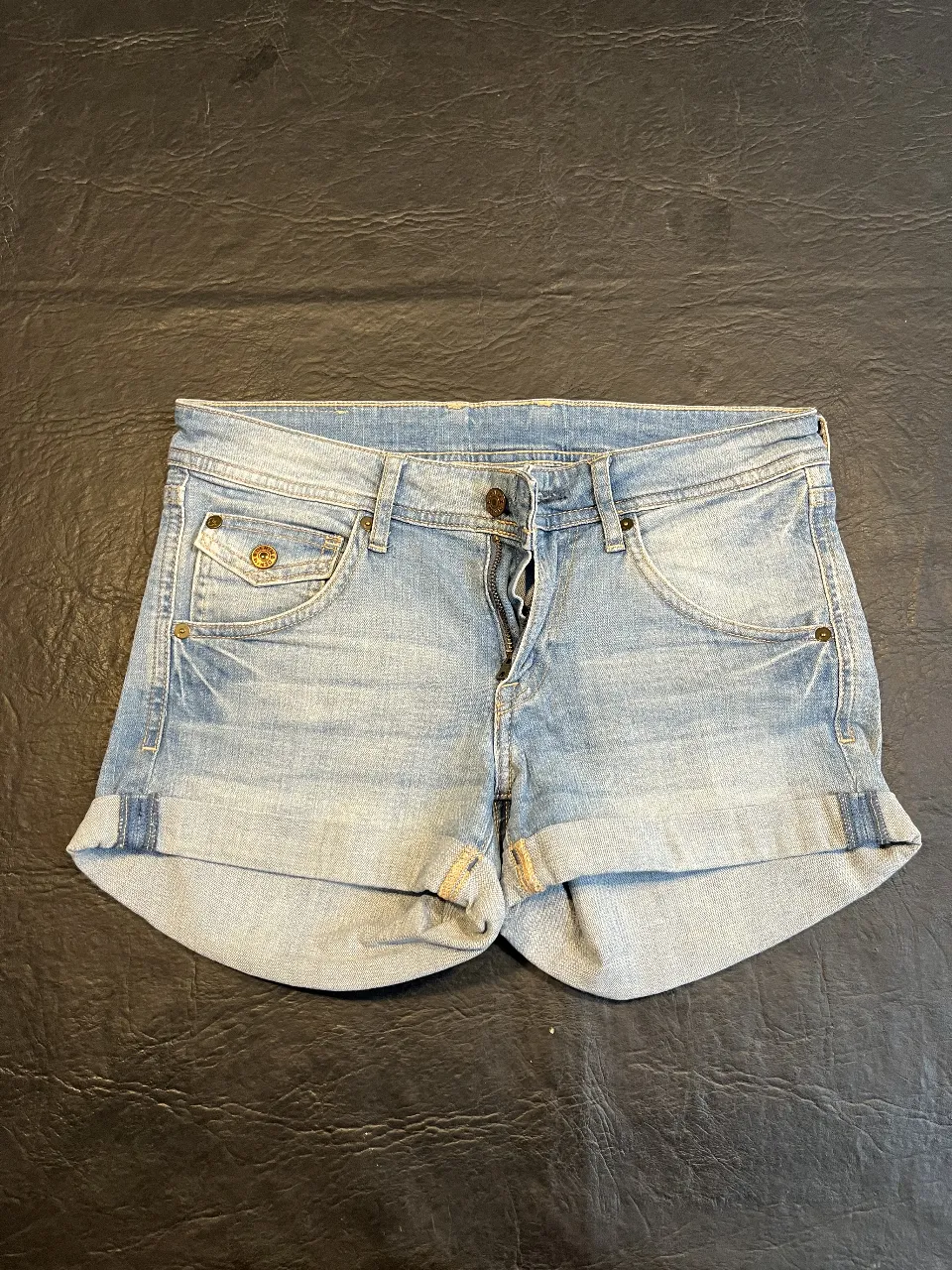 Short de jean de mujer, tiro medio, con bolsillos delanteros y traseros. Ideal para el verano.