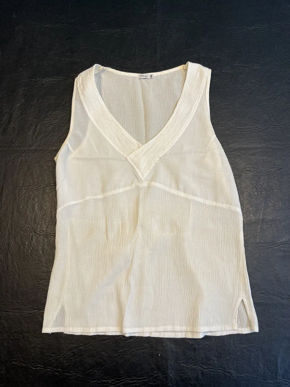 Blusa de mujer, color blanco, sin mangas, con escote en V. Ideal para un look fresco y elegante.