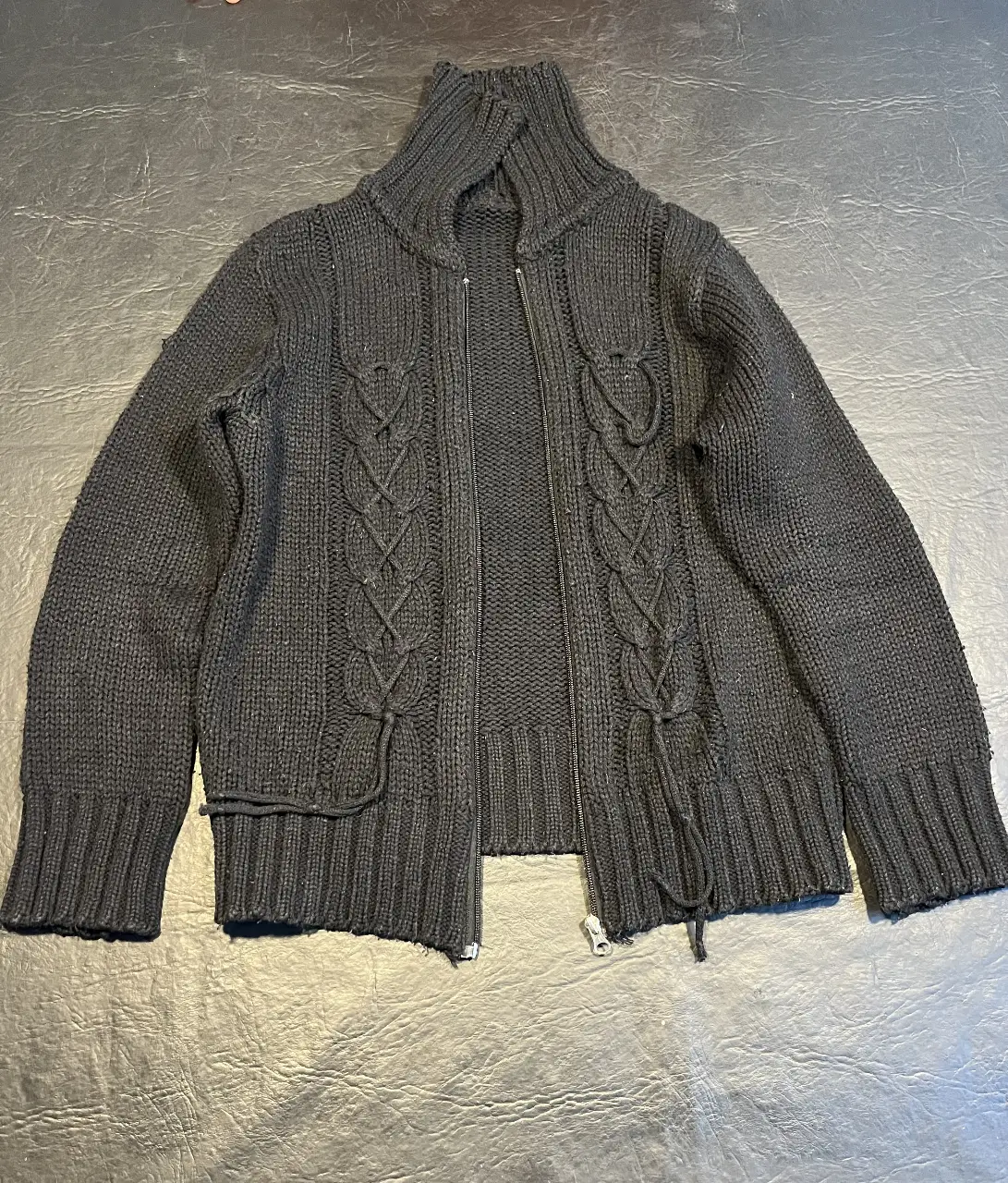 Cardigan negro tejido con cierre frontal y detalles trenzados